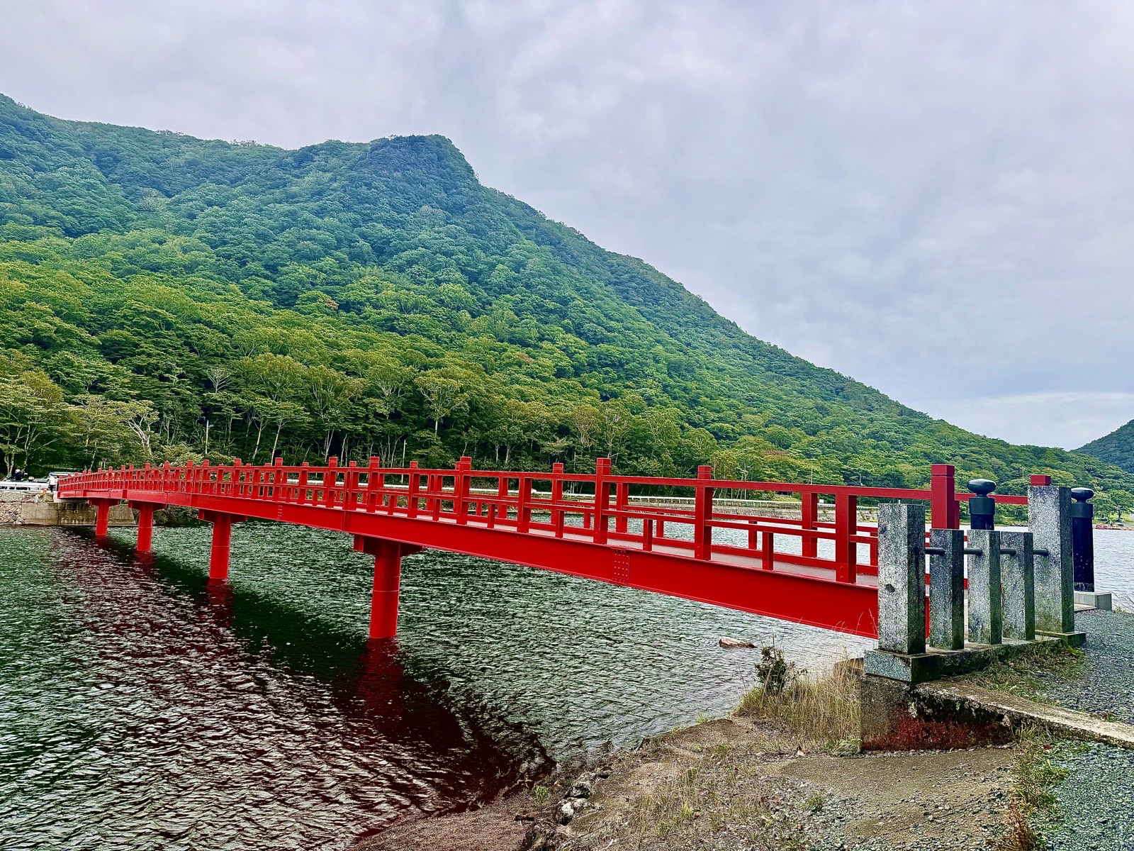 山を背に、湖へと伸びる朱塗りの橋